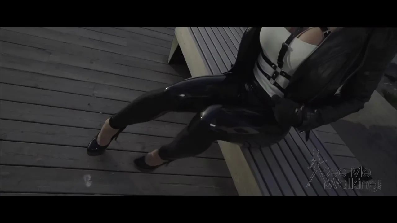 Blonde in high heels walks and sits on boardwalk, legs on display