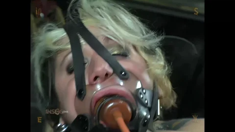Blonde in black lingerie suspended and gagged in dungeon