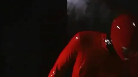 Slim brunette in red latex dominates bound guy while another woman wat