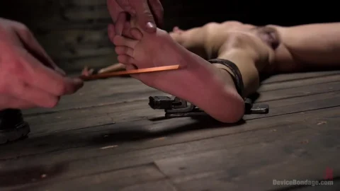 Brunette pettie tied up on wooden floor gets feet teased with pencil