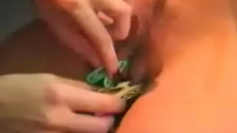 Blonde and brunette strippers apply pasties on dim lit stage