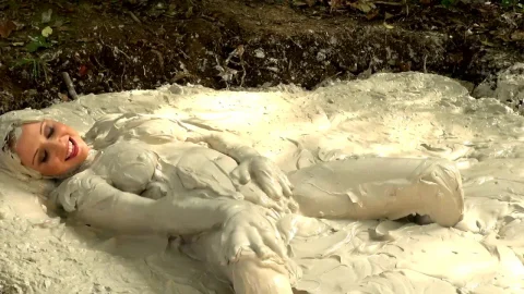 Blonde gets covered in white stuff outdoors, full body shots