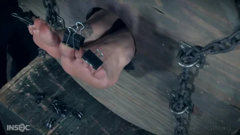 Blonde woman suspended upside down, restrained