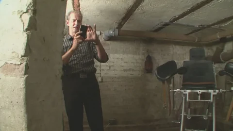 Redhead tied to metal chair, groped and photographed in dim basement d