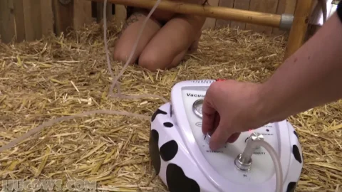 Asian girl in wooden stocks with tubes and gag in dim barn scene