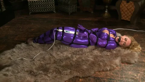 Slim blonde in purple latex bodysuit gets wired up on fur rug