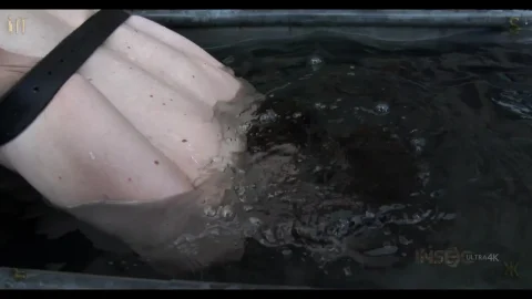 Brunette woman in BDSM chains and whip gets water tortured